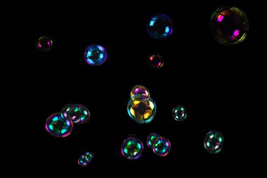 Sabun köpükleri siyah arkaplanda izole edilmiş.