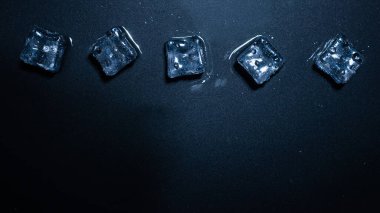 Siyah arkaplanda buz kristal küpleri, metin veya tasarım için boşluk.