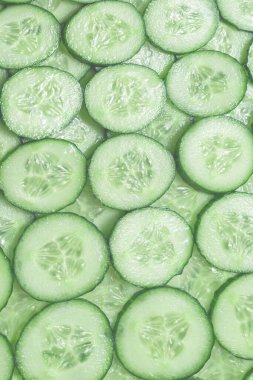 Arka plan olarak taze yeşil salatalık dilimleri. Üst görünüm. 