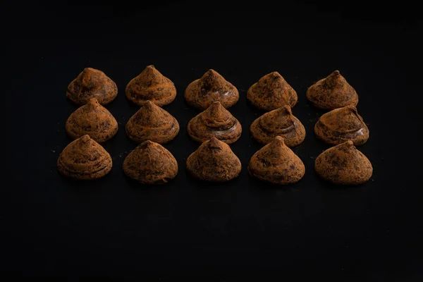 Chocolate truffles on a black background. Chocolate candies.