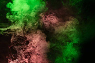 Siyah arka planda yeşil ve pembe buhar. Boşluğu kopyala.