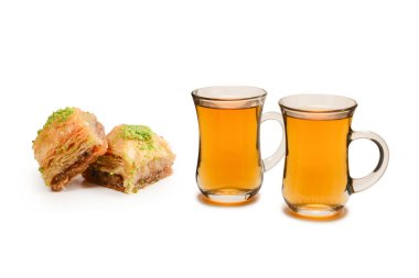 Beyaz zemin üzerinde Türk çayı bulunan Türk tatlı baklavası. . 