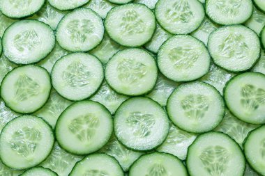 Arka plan olarak taze yeşil salatalık dilimleri. Üst görünüm. 