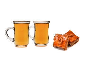 Beyaz zemin üzerinde Türk çayı bulunan Türk tatlı baklavası.