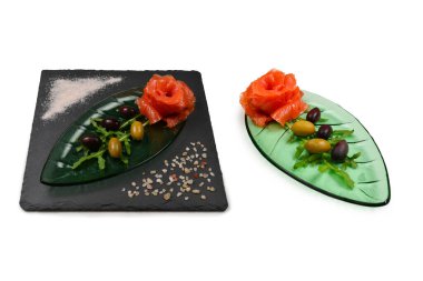 Beyaz üzerine tuz ve zeytinli bir tabakta somon dilimleri..