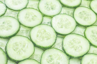 Arka plan olarak taze yeşil salatalık dilimleri. Üst görünüm. 