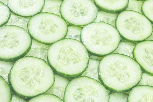 Arka plan olarak taze yeşil salatalık dilimleri. Üst görünüm. 