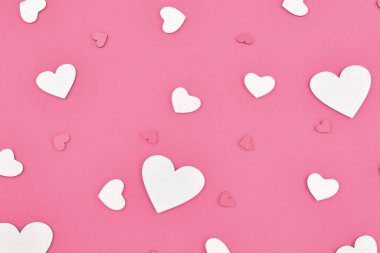 Kırmızı arka planda kırmızı ve beyaz kalpler.  