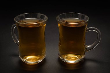 Siyah arka planda bir bardak Türk çayı..