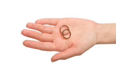 Beyaz arka planda izole edilmiş bir kadının elinde iki altın yüzük. Düğün konsepti. 