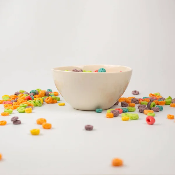 Colorful cereal box for morning breakfast. Corn flakes falling to the white bowl. Motion. Copyspace.