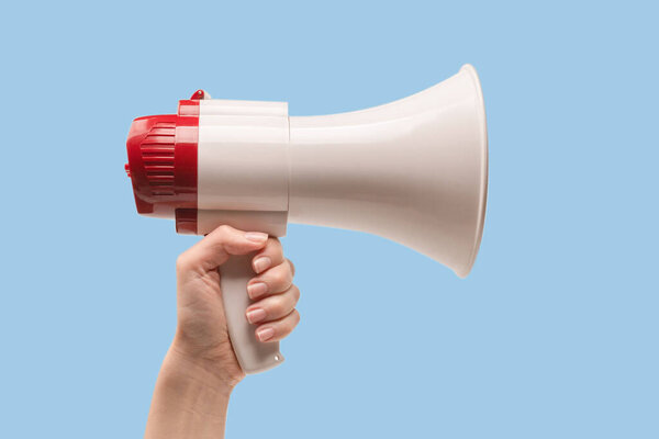 Мегафон в женских руках на белом фоне. Копирование пространства. 