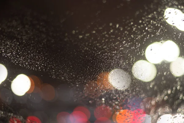 带雨滴和灯光的模糊背景 — 图库照片