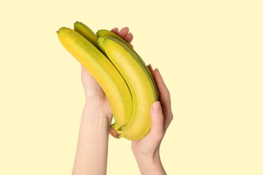 Sarı arka planda bir avuç muzu elden izole ettik..