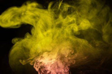 Siyah arka planda sarı ve pembe buhar. Boşluğu kopyala.