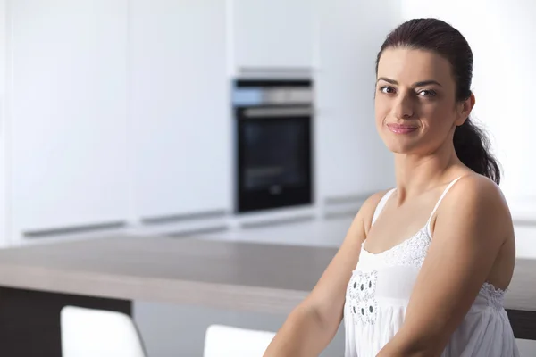 Portrait of a cheerful woman at the kitchen counter — Stock Photo, Image