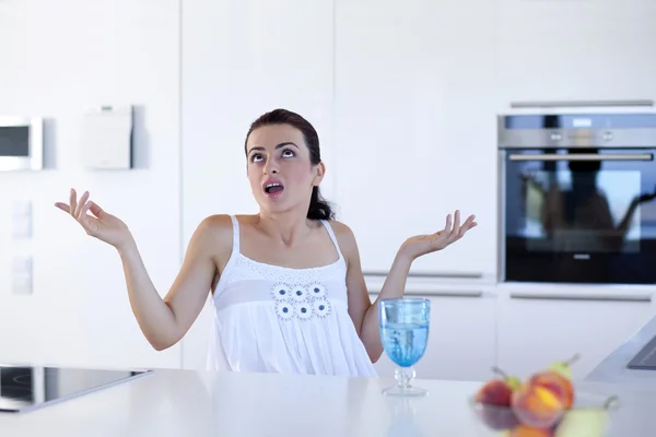 Портрет здивованої жінки на кухонній стійці — стокове фото