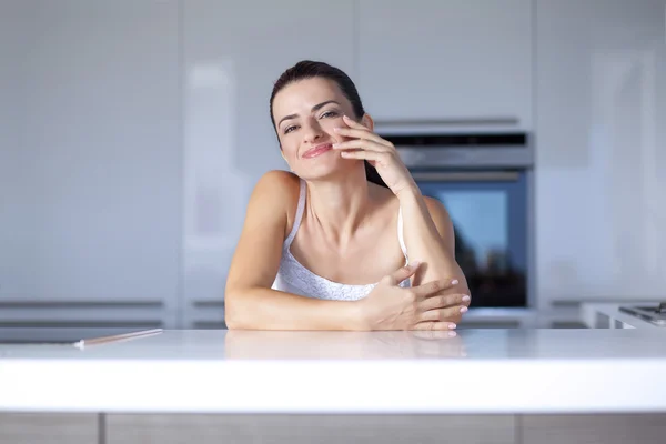Portrait of a smiling woman at the kitchen counter — Stock Photo, Image