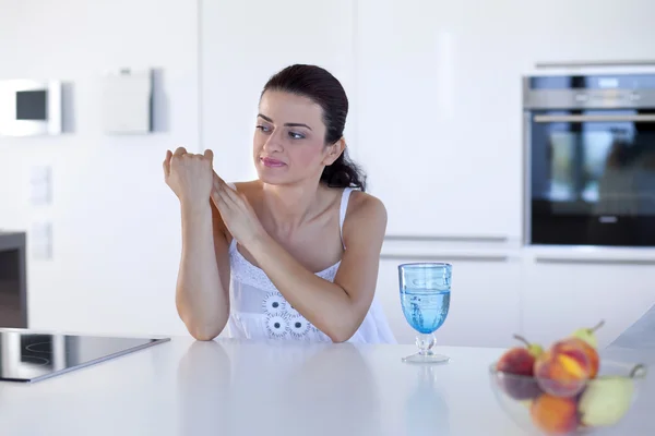 Portrait of a beautiful woman thinking at the kitchen counter — Stock Photo, Image