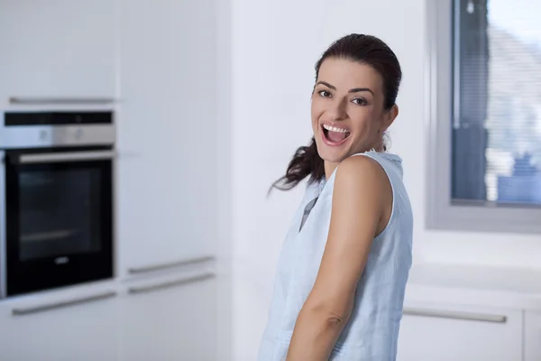 Portréja egy szép, mosolygós nő a konyhában — Stock Fotó