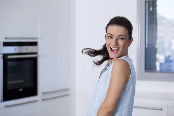 Portret van een gelukkig lachende vrouw in de keuken — Stockfoto