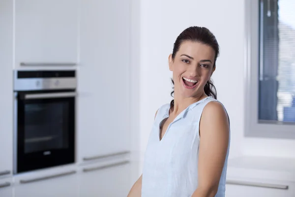 Portret van een mooie lachende vrouw in de keuken — Stockfoto
