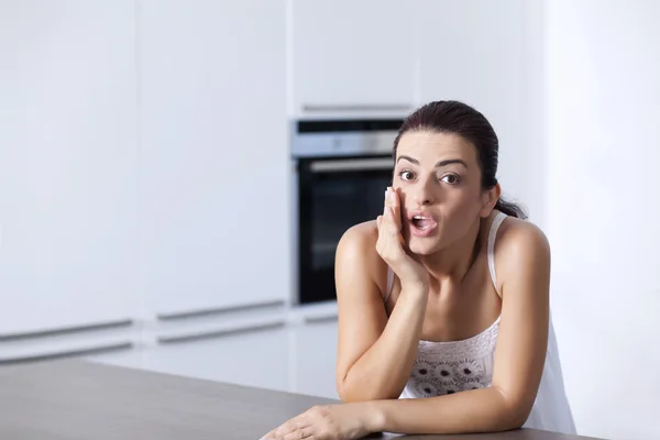 Retrato de uma mulher surpresa na cozinha — Fotografia de Stock