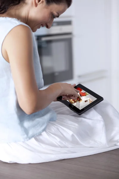 Young woman holding and touching a digital tablet — Stock Photo, Image