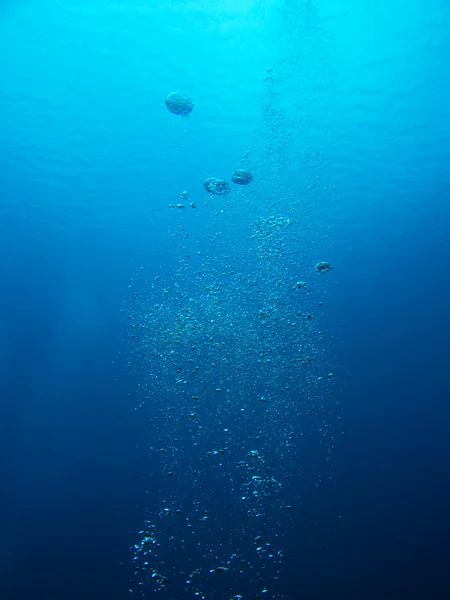 Burbujas de un buceador en el océano que sube a la superficie — Foto de Stock