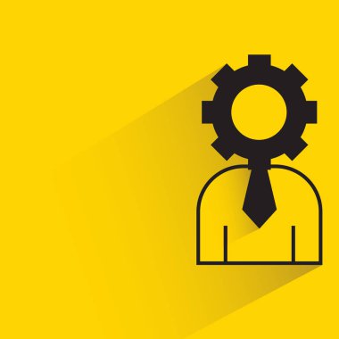 Sarı arkaplanda dişli başı simgesi olan iş adamı