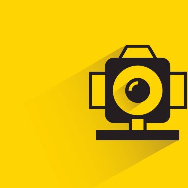 Sarı arkaplanda gölgesi olan kamera
