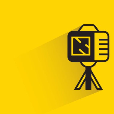 digital camera on tripod with shadow on yellow background