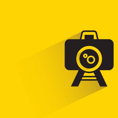 camera on tripod with shadow on yellow background