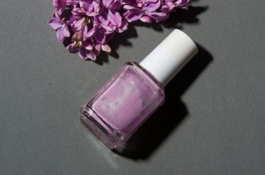 Gri arka planda leylak rengi oje ve leylak.