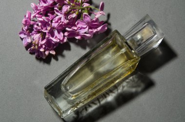 Gri arkaplanda leylaklı parfüm
