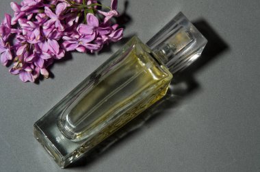 Gri arkaplanda leylaklı parfüm