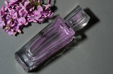 Gri arkaplanda leylaklı parfüm