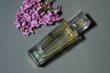 Gri arkaplanda leylaklı parfüm