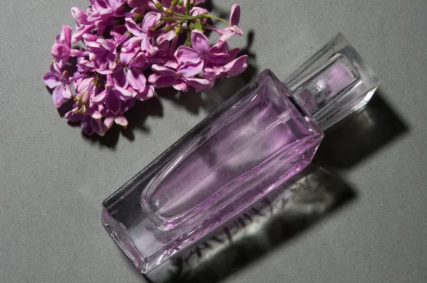 Gri arkaplanda leylaklı parfüm