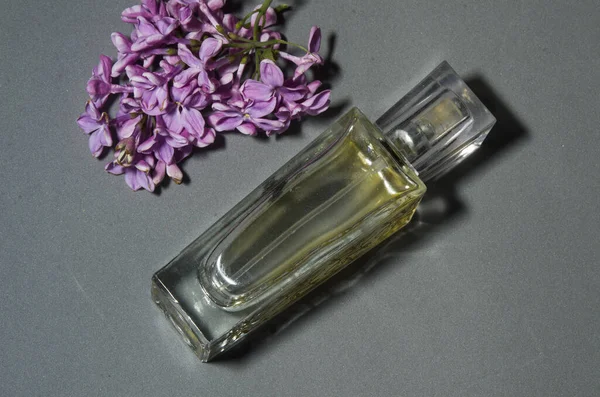 Gri arkaplanda leylaklı parfüm