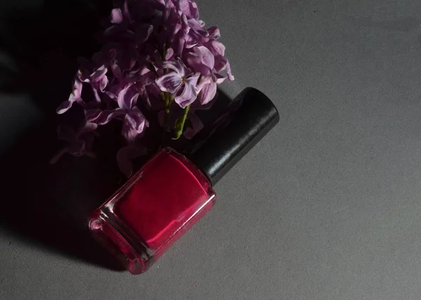 Gri bir arka planda, leylaklı kırmızı oje.