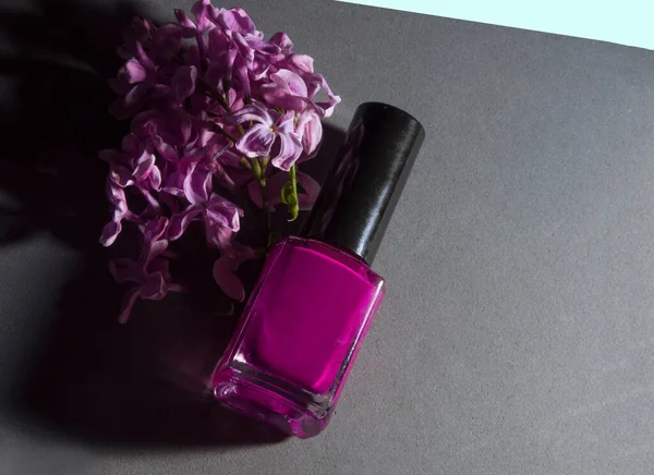 Gri arka planda leylak rengi oje ve leylak.