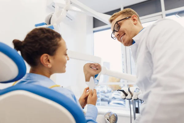 Médico Sorridente Mulher Olhando Espelho Verificando Dentes Após Procedimento Odontológico — Fotografia de Stock