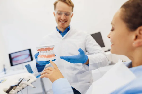 Cliente Feminino Feliz Ortodontista Masculino Olhando Para Modelo Mandíbulas Juntos — Fotografia de Stock