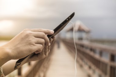 genç kadın bir tablet telefon açık havada kullanarak mutlu