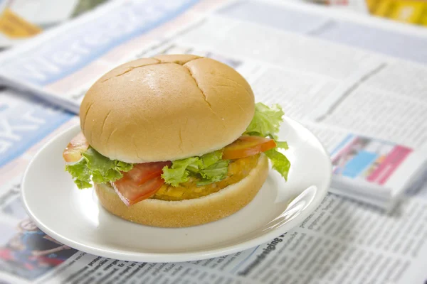 Grande hambúrguer no jornal — Fotografia de Stock