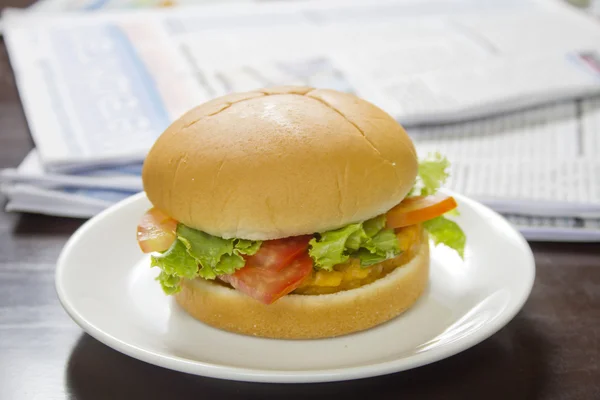 Grande hambúrguer no jornal — Fotografia de Stock