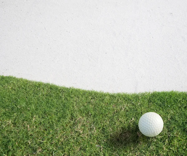 Bola de golfe branco na grama verde lado esquerdo fundo — Fotografia de Stock