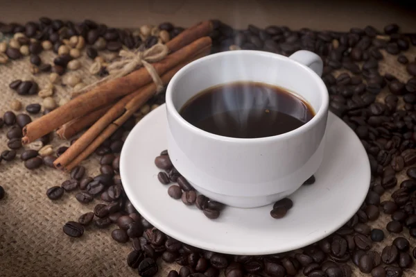 Kaffekopp och fat på ett träbord. Mörk bakgrund. — Stockfoto