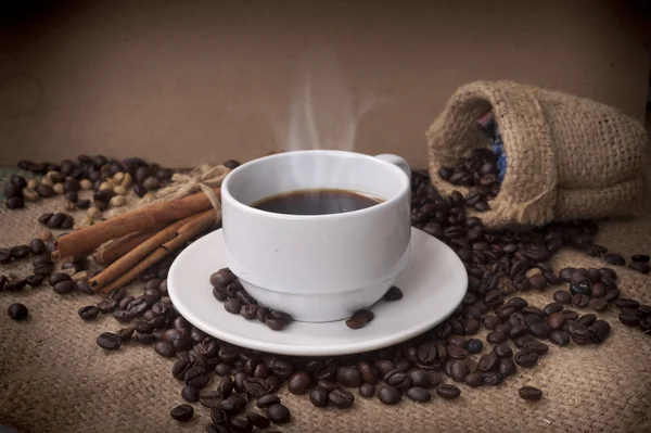 Kaffekopp och fat på ett träbord. Mörk bakgrund. — Stockfoto